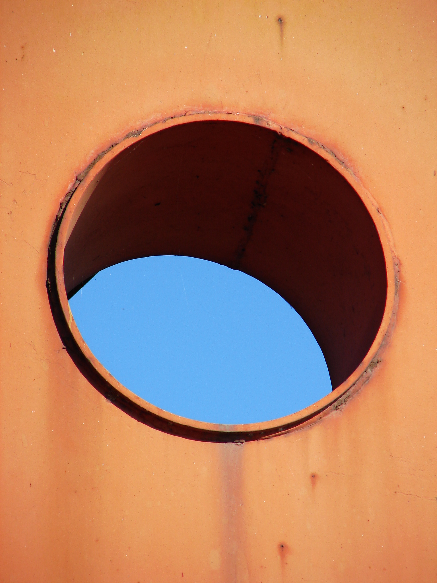 a circular hollow within a red square facing the sky